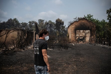 A resident of Le Porge inspects damage caused by the fire.Photograph: Julien de Rosa/AFP/Getty Images