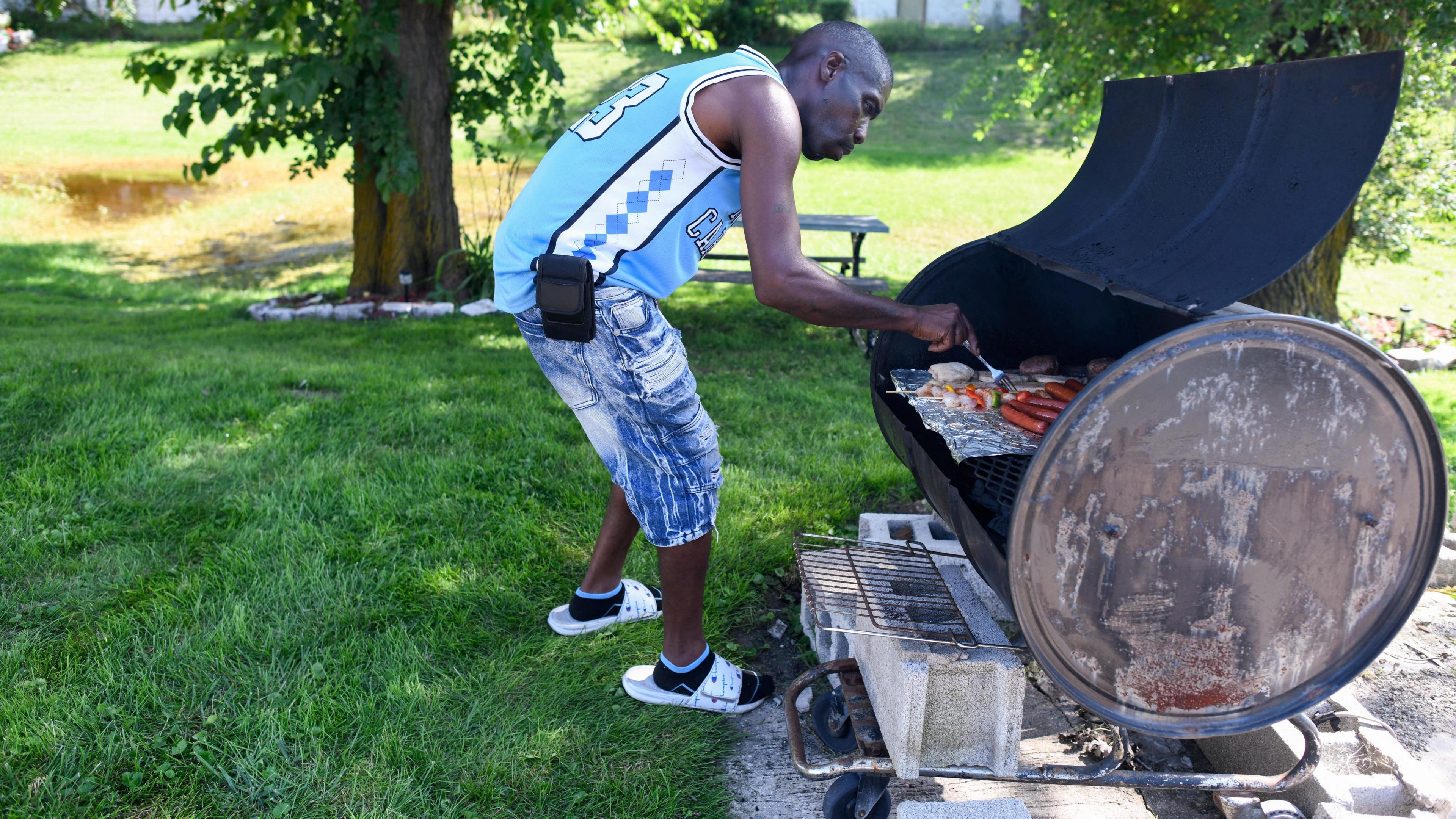 Image caption,Demond Pompy, who has been grilling food in Gary during the power outage, told Reuters earlier this week that taking a shower and flushing the toilet are things people take for granted, but defiantly added: "One thing about us, we're going to adapt to any situation"