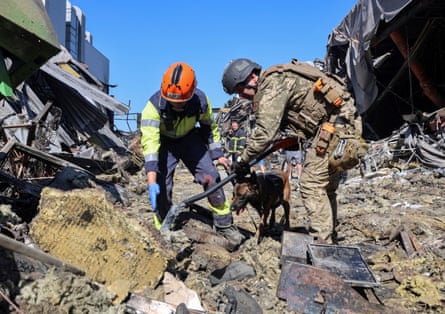 Rescuers with a dog work at the site of a Russian drone attack on a shopping centre in Kryvyi Rih on Saturday.Photograph: Serhii Chalyi/Reuters