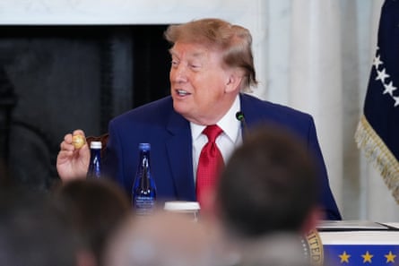 Donald Trump holds up a gold replica of a deep sea nodule given to him at a mining industry event earlier this month.Photograph: Eric Lee/Getty Images