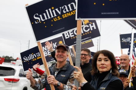 Dan Sullivan and his wife, Julie Fate Sullivan hold signs at an intersection during morning rush hour traffic in Anchorage, Alaska, on 18 August.Photograph: Mark Thiessen/AP