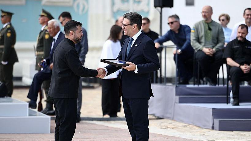 Image caption,Burnham accepts an award from Volodymyr Zelensky on behalf of the British people recognising the UK's support for Ukraine