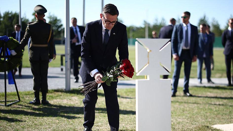 Image caption,Burnham lays flowers at the graves of Ukrainian soldiers during a Monday service