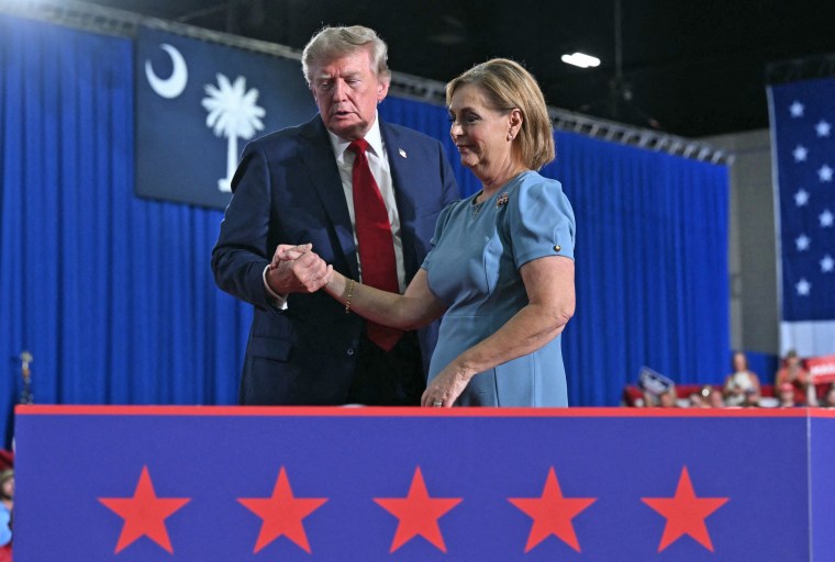 President Donald Trump helps Sen. Darline Graham off the stage during a campaign rally in Myrtle Beach, S.C., on Aug. 21.Saul Loeb / AFP via Getty Images
