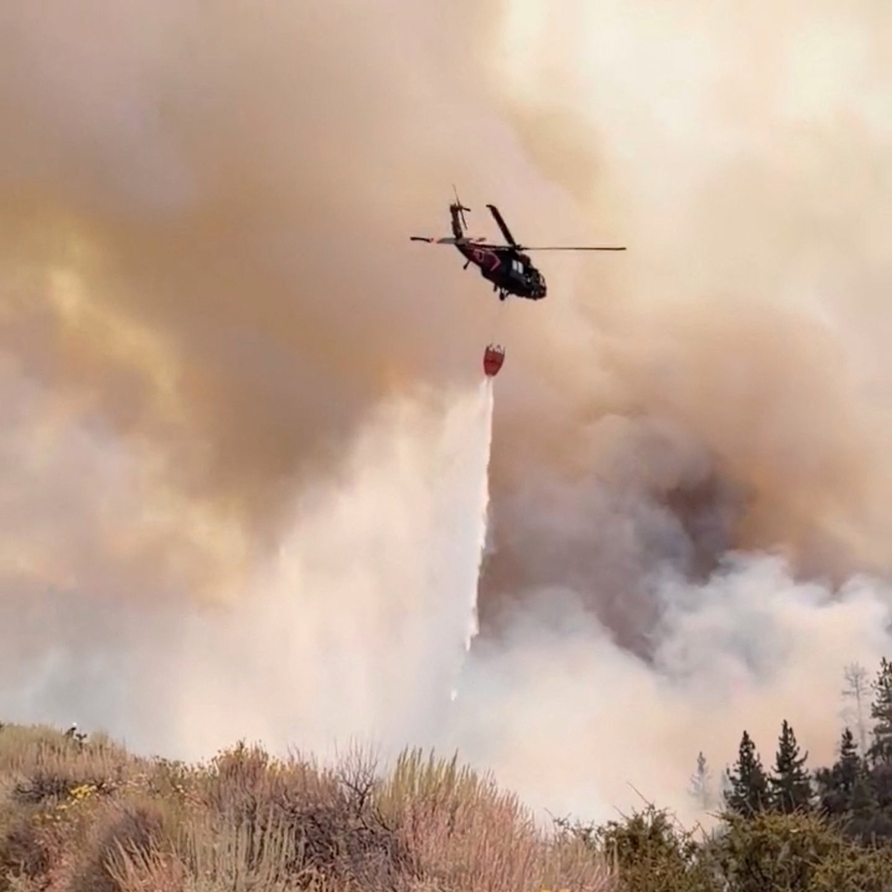 A Nevada National Guard helicopter drops water on the Hawk Fire, as the wildfire burns, near Reno, Nevada, August 23, 2026.Nevada National Guard/via Reuters