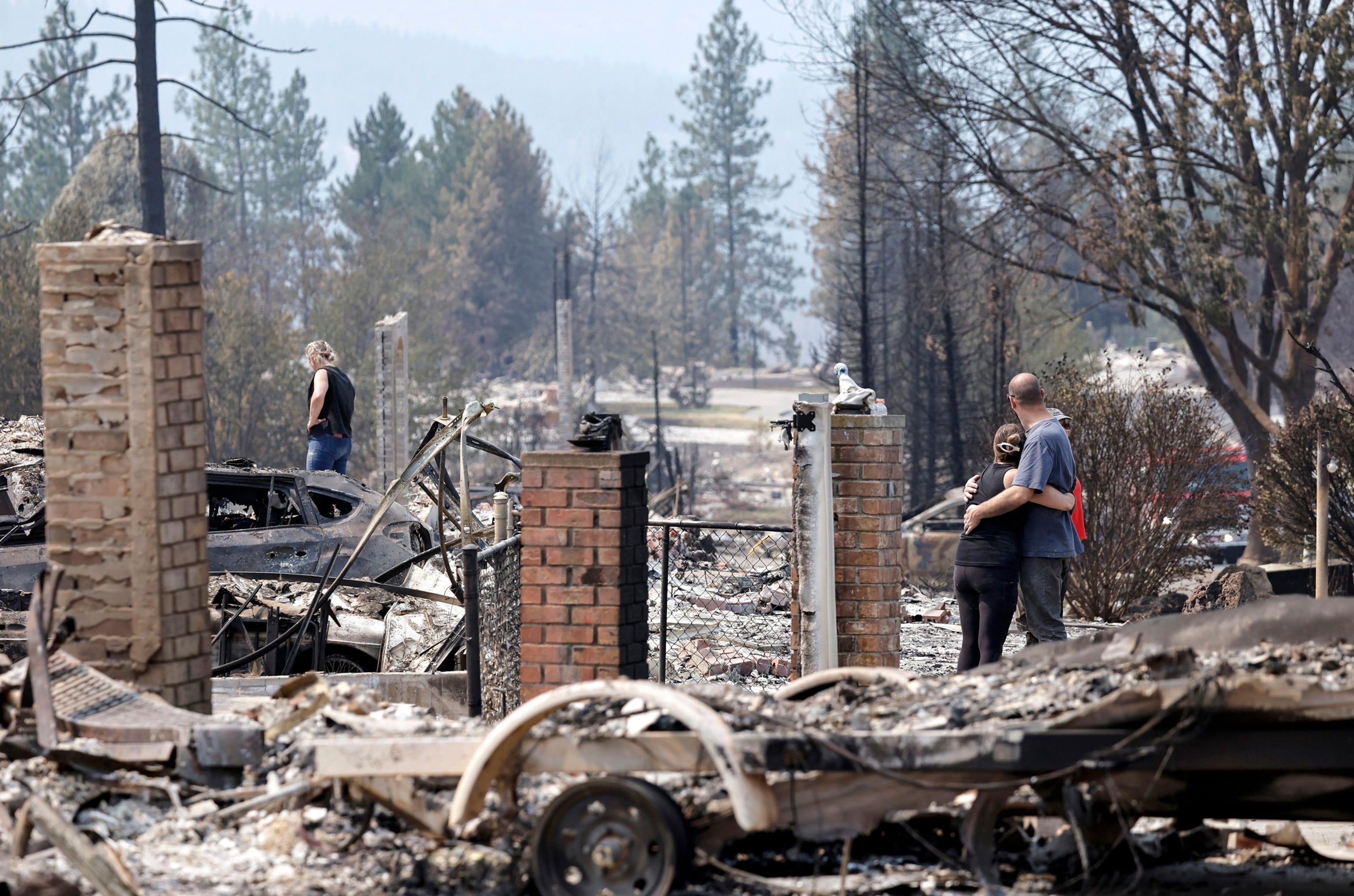 People embrace while searching for items in the remains of a home which was destroyed in the Old Trails Fire on Aug. 7, 2026, in Spokane, Washington.Mario Tama/Getty Images