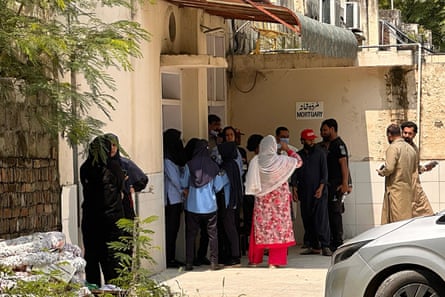 Police officers peer through broken windows of the gynecology ward after the fire.Photograph: MA Sheikh/AP