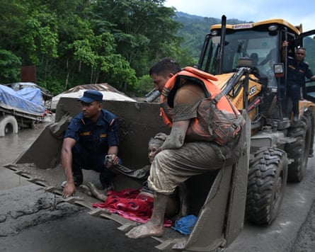 Rescuers use a digger to move a survivor of the flash flood to safety in the Nuwakot district of Nepal.Photograph: Prakash Mathema/AFP/Getty Images