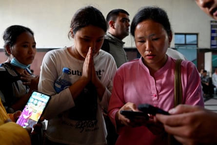 Family members outside a trauma centre at Bir hospital in Kathmandu check a list of people who were injured.Photograph: Monika Malla/Reuters