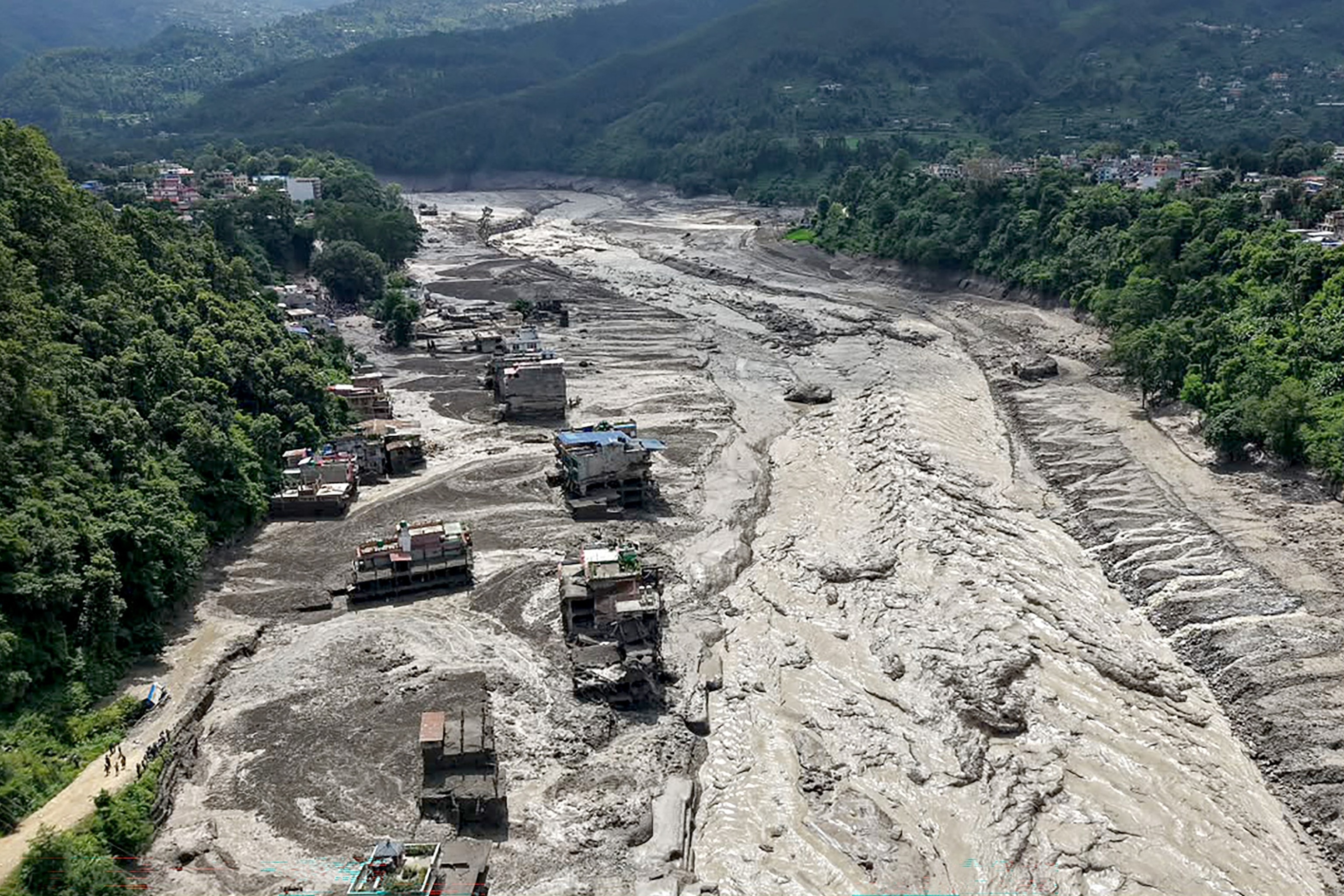 A resident walks along a street covered in mud following flash floods and a landslide disaster in Devghat, in Nepal's Nuwakot district, August 26, 2026.Prakash Mathema/AFP via Getty Images