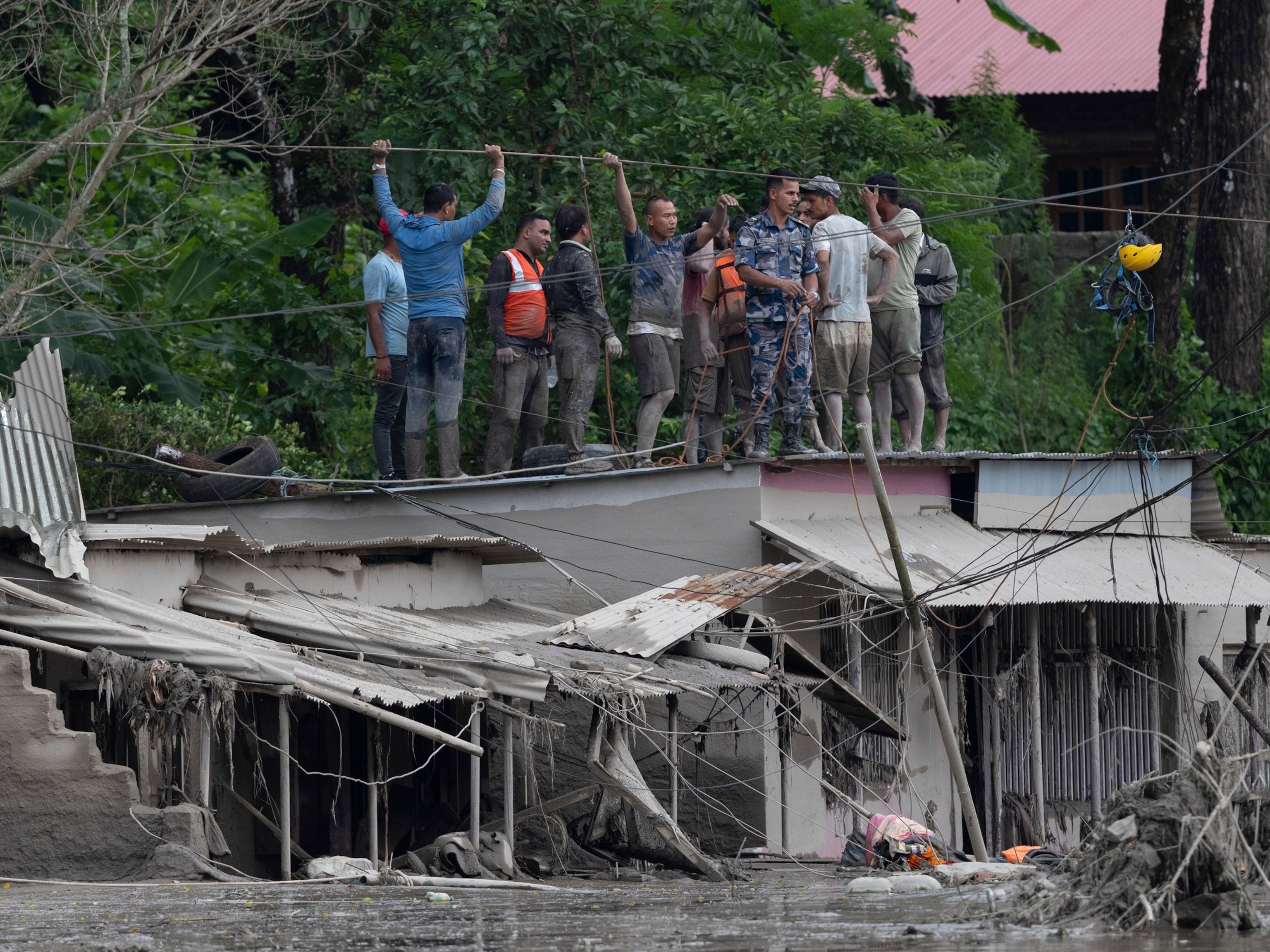Rescuers gather on a rooftop as floodwaters sweep through Trishuli Bazar following a flash flood, in Nuwakot district, Nepal, August 26, 2026.Narendra Shrestha/EPA/Shutterstock