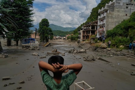 A child looks at the damage caused by the flooding along the Trishuli River.Photograph: Niranjan Shrestha/AP