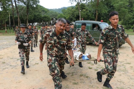 Nepali soldiers carrying a survivor of the flash flood.Photograph: Nepal Army/EPA