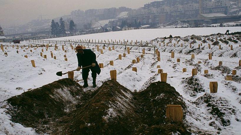 Image caption,A gravedigger buries civilians killed in the siege of Sarajevo in 1993