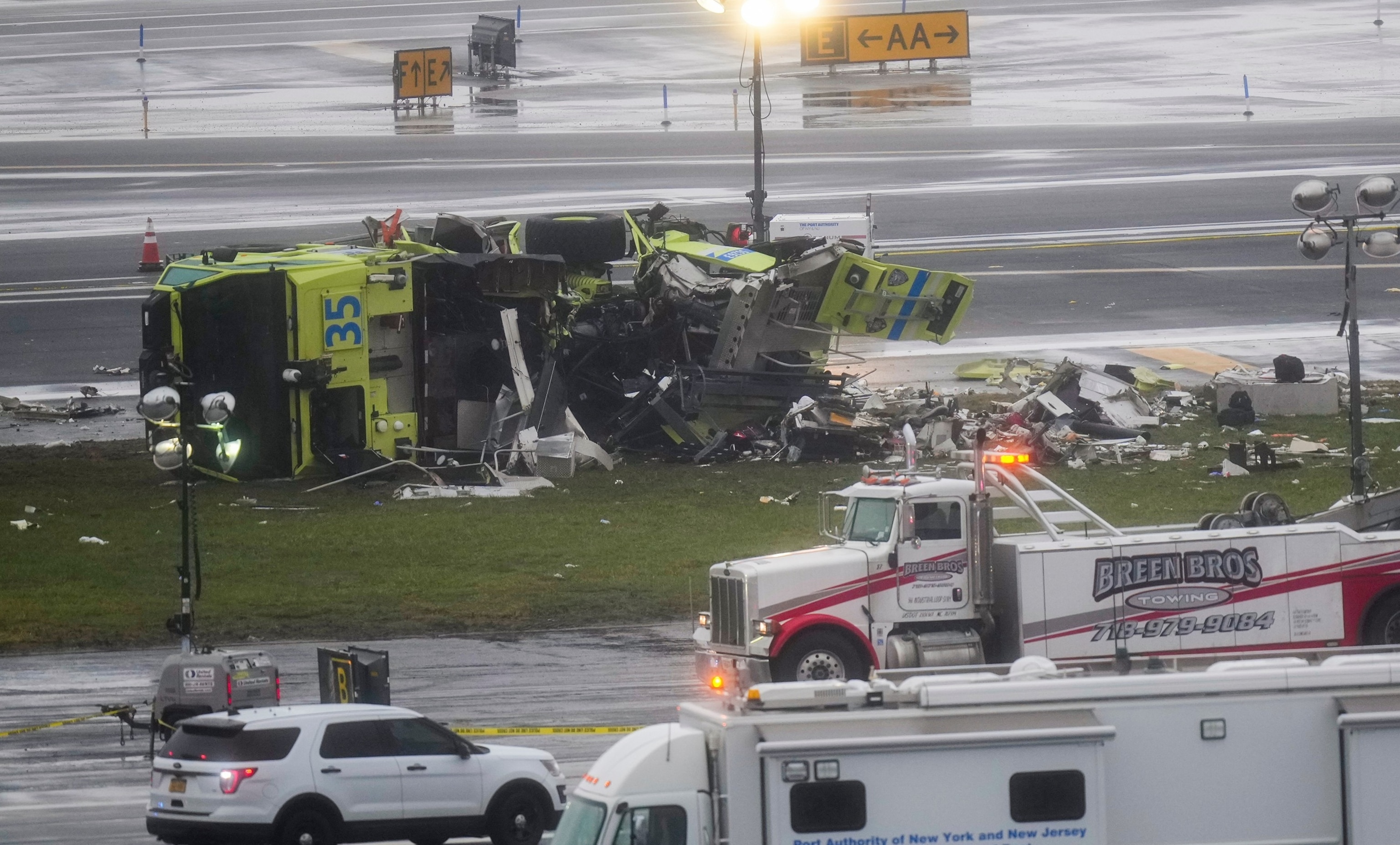 An Air Canada jet and A Port Authority fire truck sits on its side off the side of the runway at LaGuardia Airport, March 23, 2026, after colliding with an Air Canada jet after it landed in New York.Seth Wenig/AP