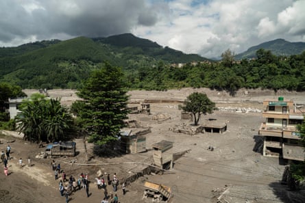 People surveying the aftermath of the flooding in Bidur.Photograph: Ahmer Khan/The Guardian