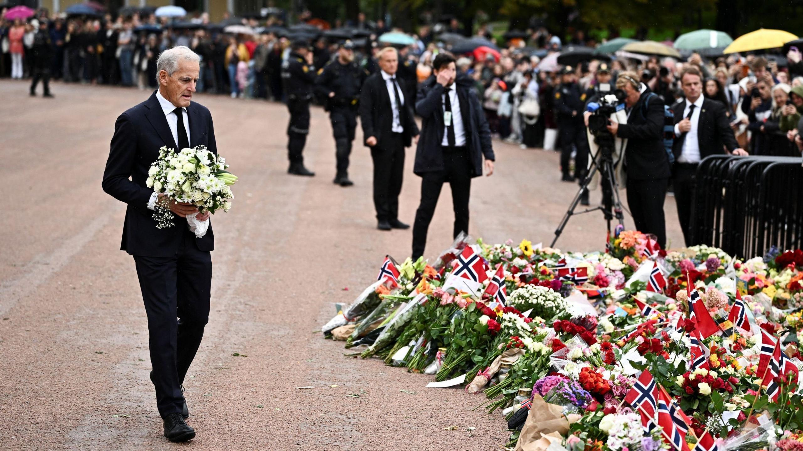 Image caption,Støre was joined by ministers and a crowd of citizens grieving outside the palace