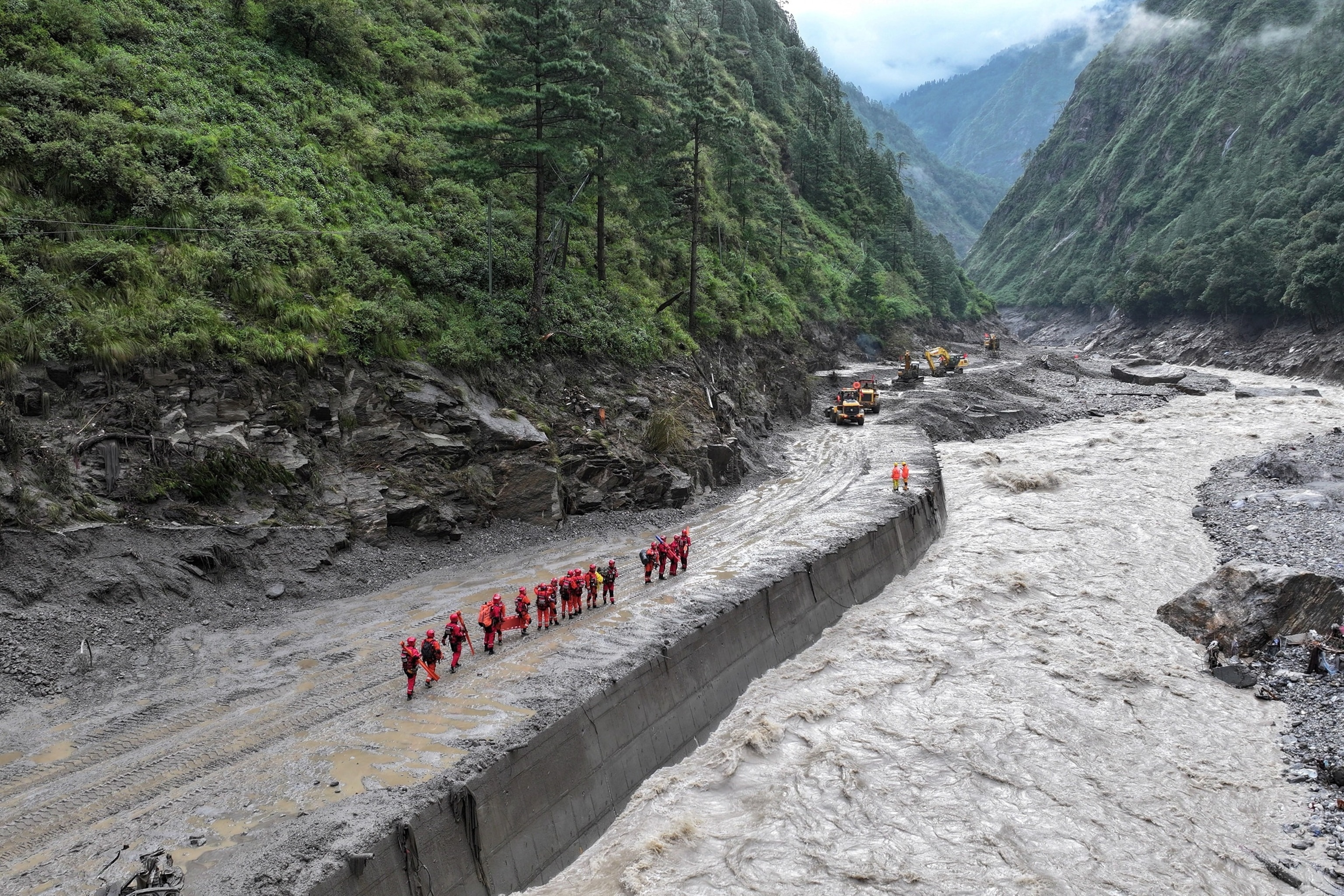 Firefighters conduct a search and rescue operation at a damaged road leading to Gyirong Port after a mudslide, in Gyirong county, Shigatse, Tibet Autonomous Region, China, August 28, 2026.Cnsphoto via Reuters