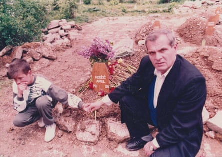 Džemil and his father at Amel’s grave after his funeral.Photograph: Family handout