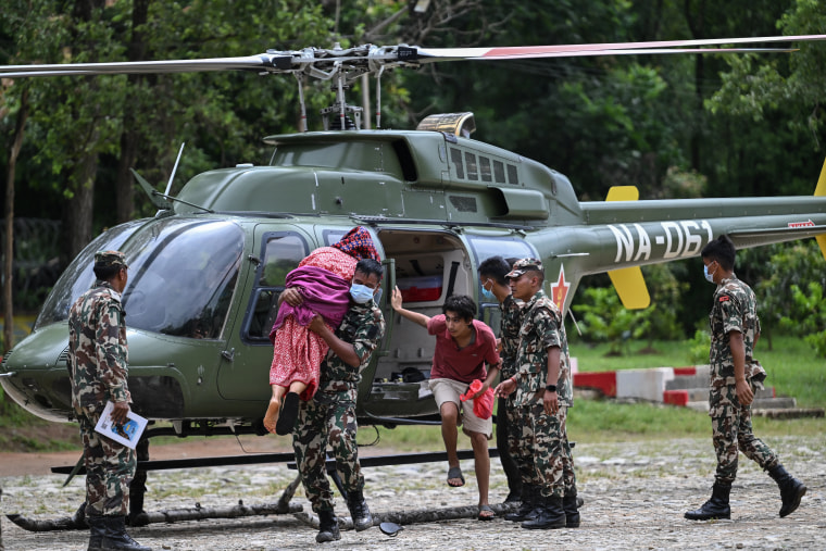 An Army personnel carries out an elderly woman from a helicopter during a rescue operation in the aftermath of Nepal-Tibet flash floods at Trishuli camp in Nuwakot district on Aug. 29.Arun Sankar / AFP via Getty Images