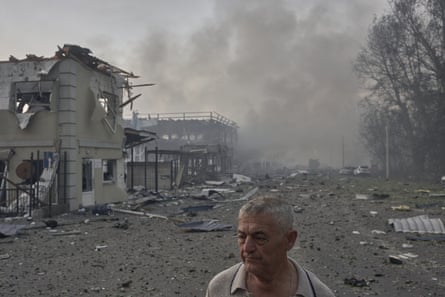 A man walks past destroyed houses after the Russian strike in Bucha.Photograph: Libkos/Getty