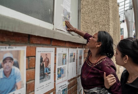 Relatives look through the lists of missing flood victims at the teaching hospital.Photograph: Ahmer Khan/The Guardian