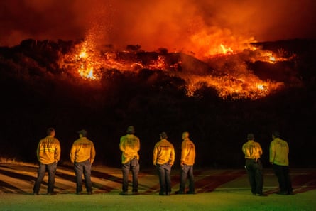 Firefighters watch as the Plaskett fire burns toward Highway 1 on Friday.Photograph: Ethan Swope/AP