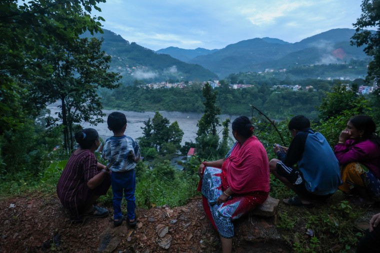 Residents living along Trishuli River in Bidir, Nuwakot, Nepal, take shelter at higher ground on Aug. 30 after fleeing homes early in the morning, as authorities issue new flash flood warning.Daniel Ceng / Anadolu via Getty Images