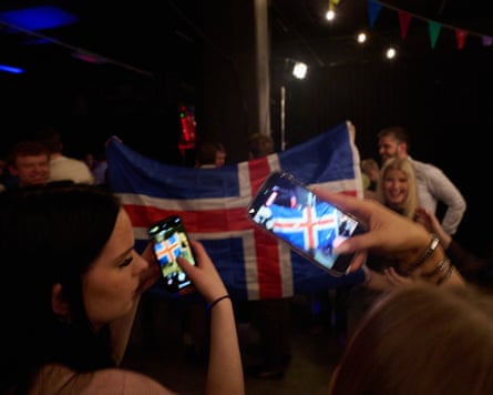 People wave an Icelandic flag at a referendum-night event organised by the no campaign.Photograph: Halldor Kolbeins/AFP/Getty Images