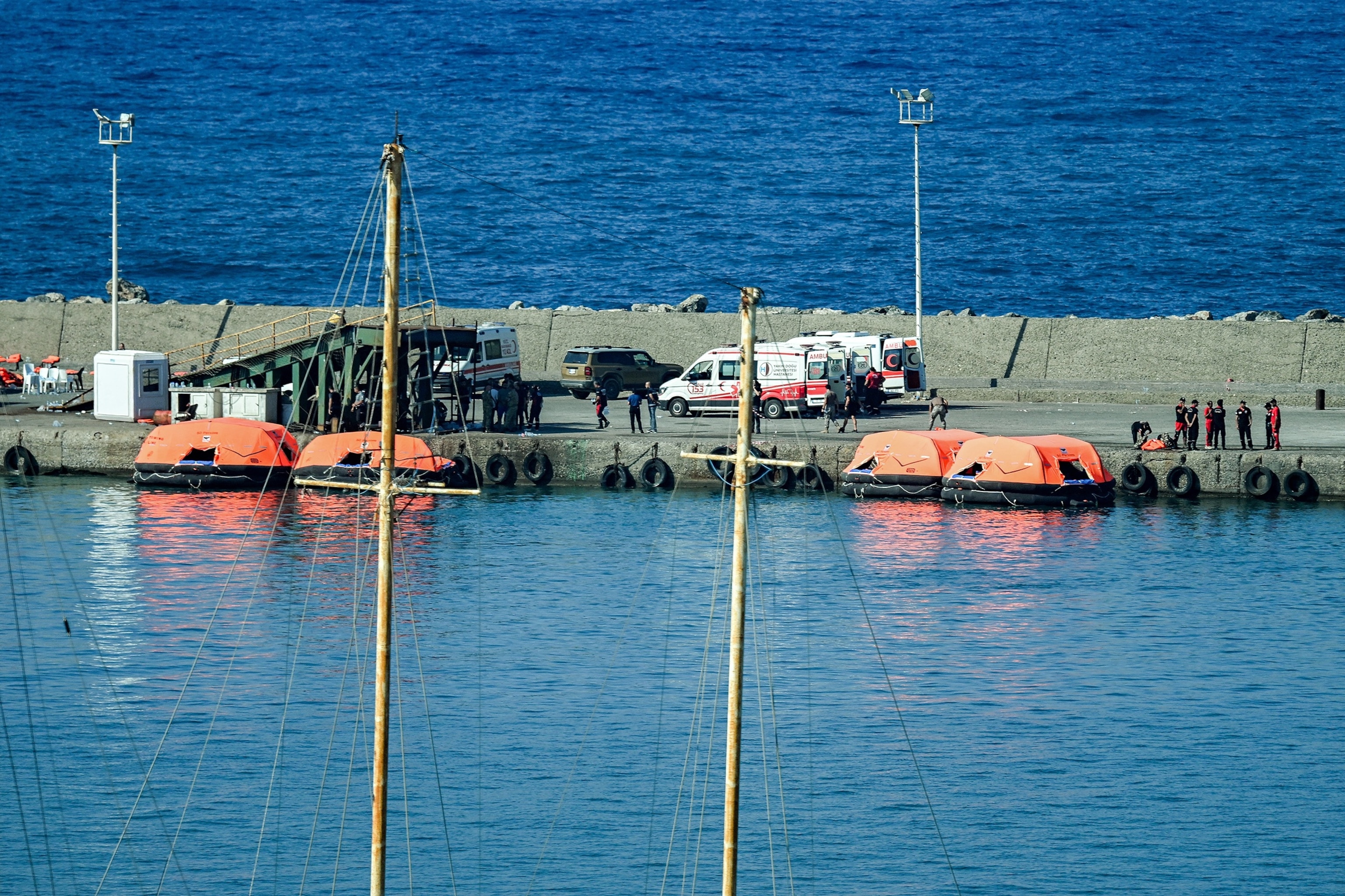 First responders gather by docked rescue rafts along a pier at the port of Kyrenia in the self-proclaimed Turkish Republic of Northern Cyprus (TRNC), recognised only by Turkey, in the north of the divided Mediterranean island of Cyprus on August 30, 2026 during search and rescue operations following a ferry capsizing.Jewel Samad/AFP via Getty Images