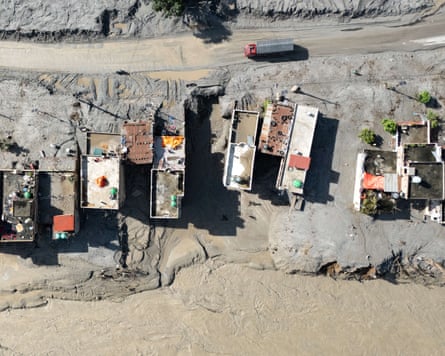 A vehicle drives past houses covered in mud in Baireni, in the Dhading district of Nepal.Photograph: Manan Vatsyayana/AFP/Getty Images