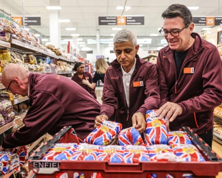 Sadiq Khan (centre) stacks shelves in a Sainsbury’s in London with Andy Burnham, the prime minister, and Pat McFadden, work and pensions secretary.Photograph: WPA/Getty