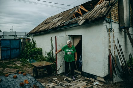 Liudmyla near her damaged house.Photograph: Julia Kochetova/The Guardian
