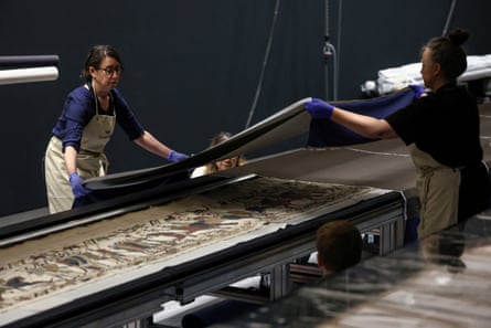 Museum staff adjusting protective covers on the Bayeux tapestry.Photograph: Toby Shepheard/AFP/Getty Images