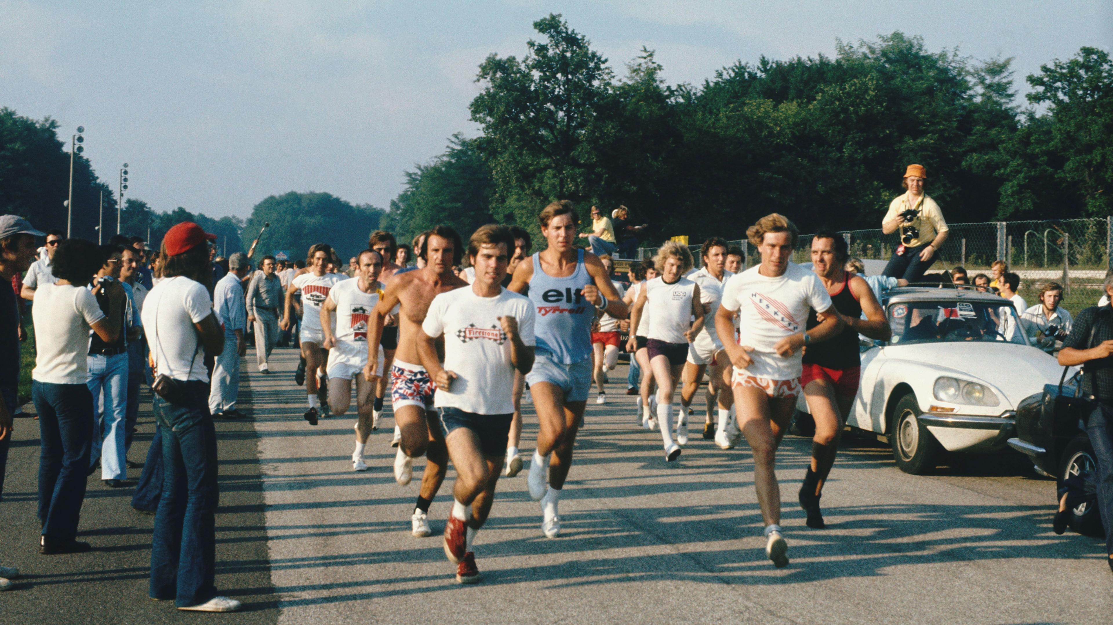 Image caption,Drivers and team members set off on a race around the circuit in 1973, organised by  team owner Frank Williams. At the front of the pack is James Hunt but it would be Williams - who can be seen behind the bare-chested runner - who won and took the £750 prize.