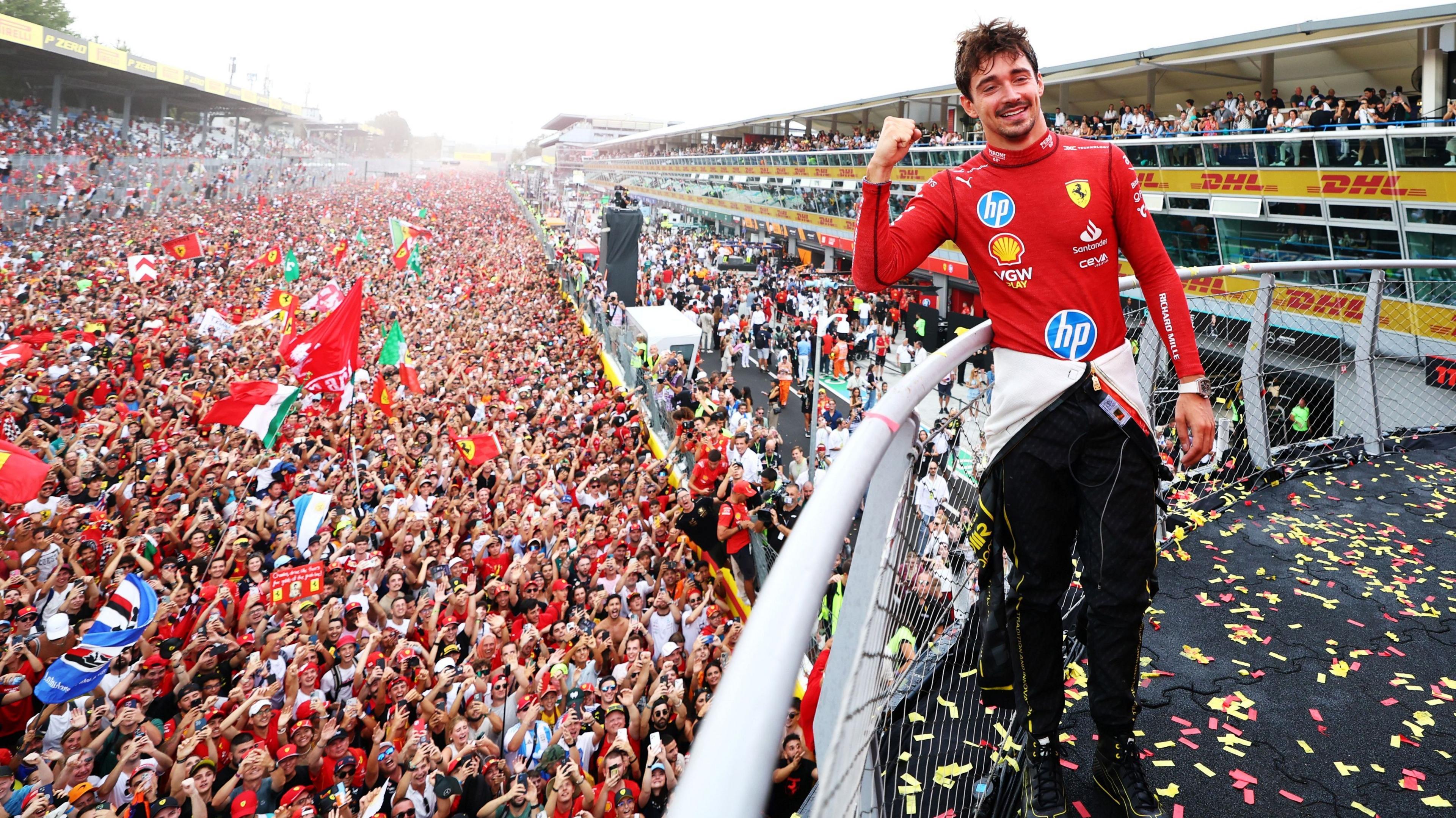 Image caption,Charles Leclerc takes in the acclaim from the tifosi below him after winning for Ferrari in 2024 - his second victory at Monza after success in 2019.
