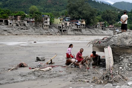 People try to salvage belongings from their devastated homes in Devighat.Photograph: Arun Sankar/AFP/Getty Images