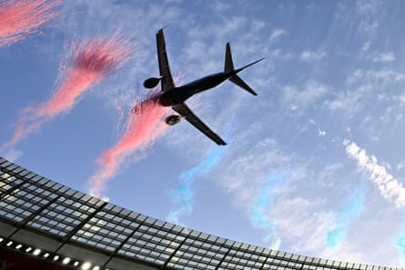 The second jet flies through a cloud of pink dust that shot up from the stadium roof as part of the show.Photograph: AP
