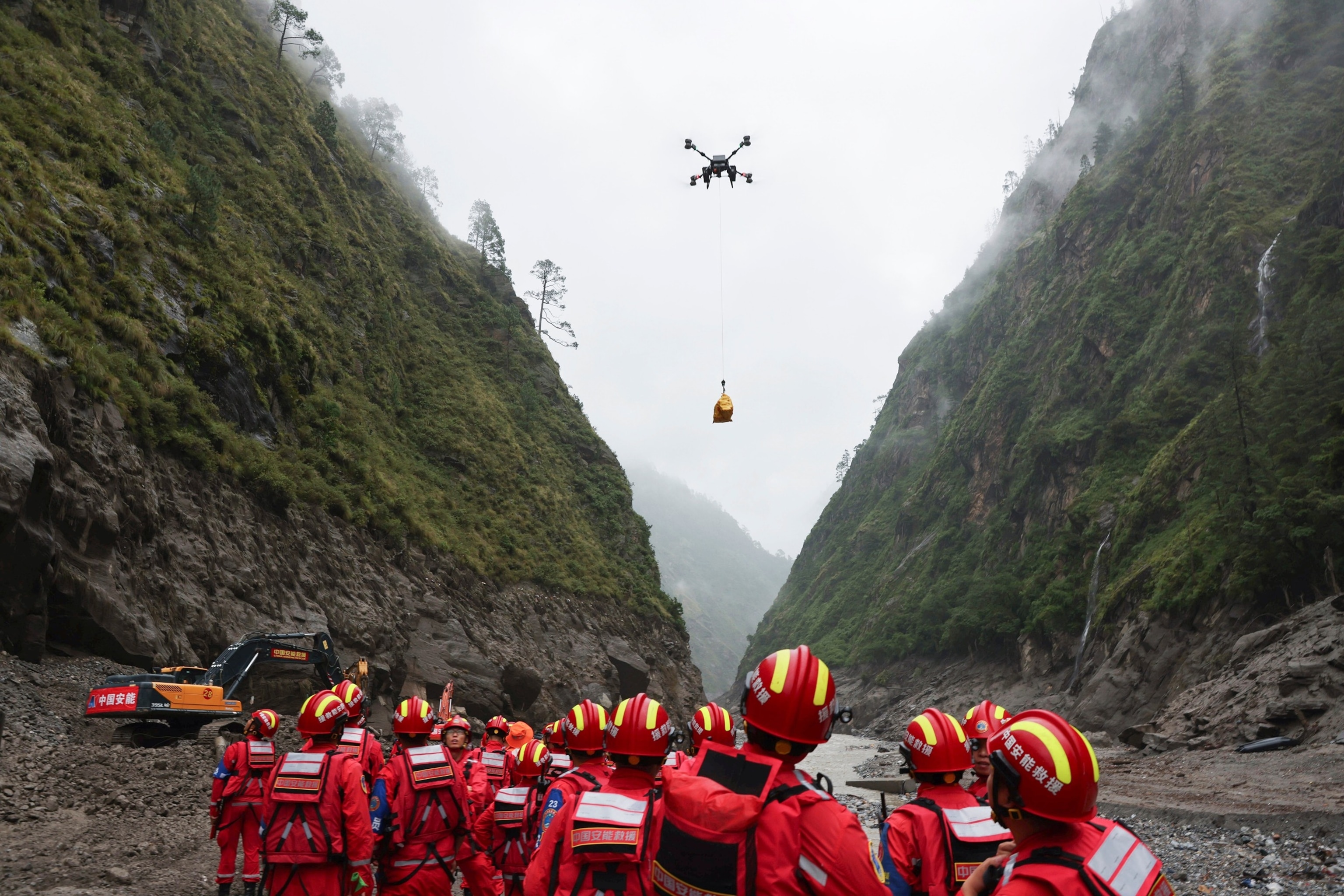 In this photo released by Xinhua News Agency, a drone carries cargo overhead as search and rescue operations are underway at the mudslide-hit area in Gyirong County, southwestern China's Tibet Autonomous Region, on Aug. 29, 2026.Jiang Fan/Xinhua via AP