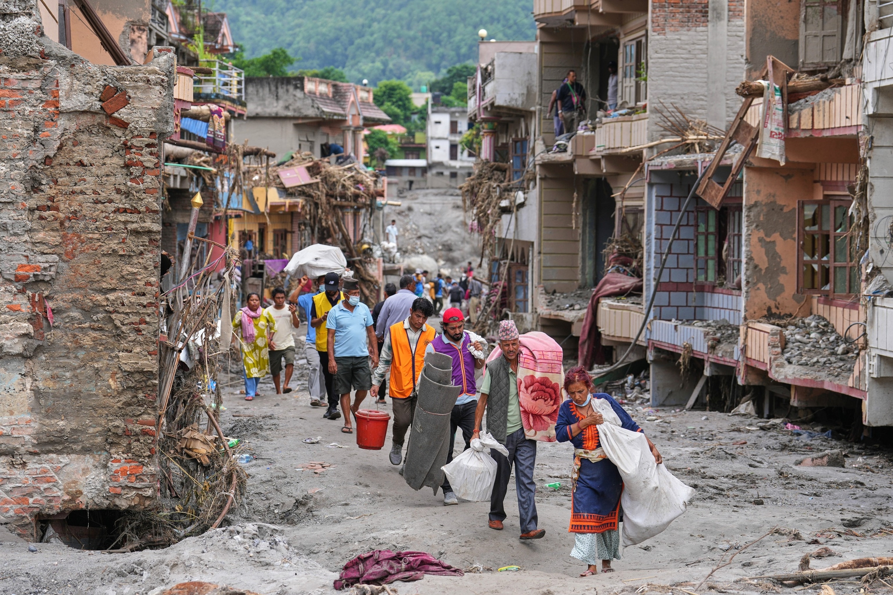 Residents carry their belongings salvaged from their damaged homes filled with mud and debris in Devighat, in Nepal's Nuwakot district, on Aug. 29, 2026, following the Aug. 26 flash floods.Rajesh Kumar Singh/AP Photo
