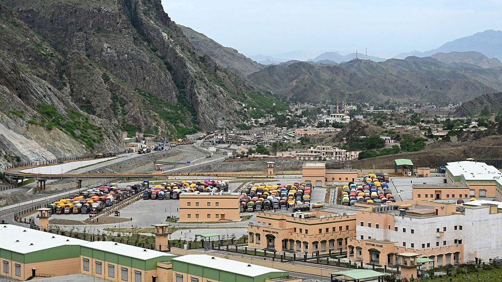 Image caption,Trucks carrying returnees parked along the highway near the border