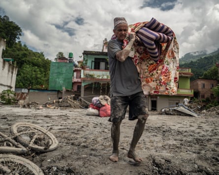 ‘[Floods] might happen any time’ … a Devighat resident retrieves some of his belongings.Photograph: Ahmer Khan/The Guardian