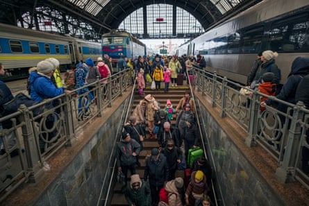 Refugees arriving in Lviv on evacuation trains from Kharkiv and Kryvy Rih make their way through the train station.Photograph: Jelle Krings