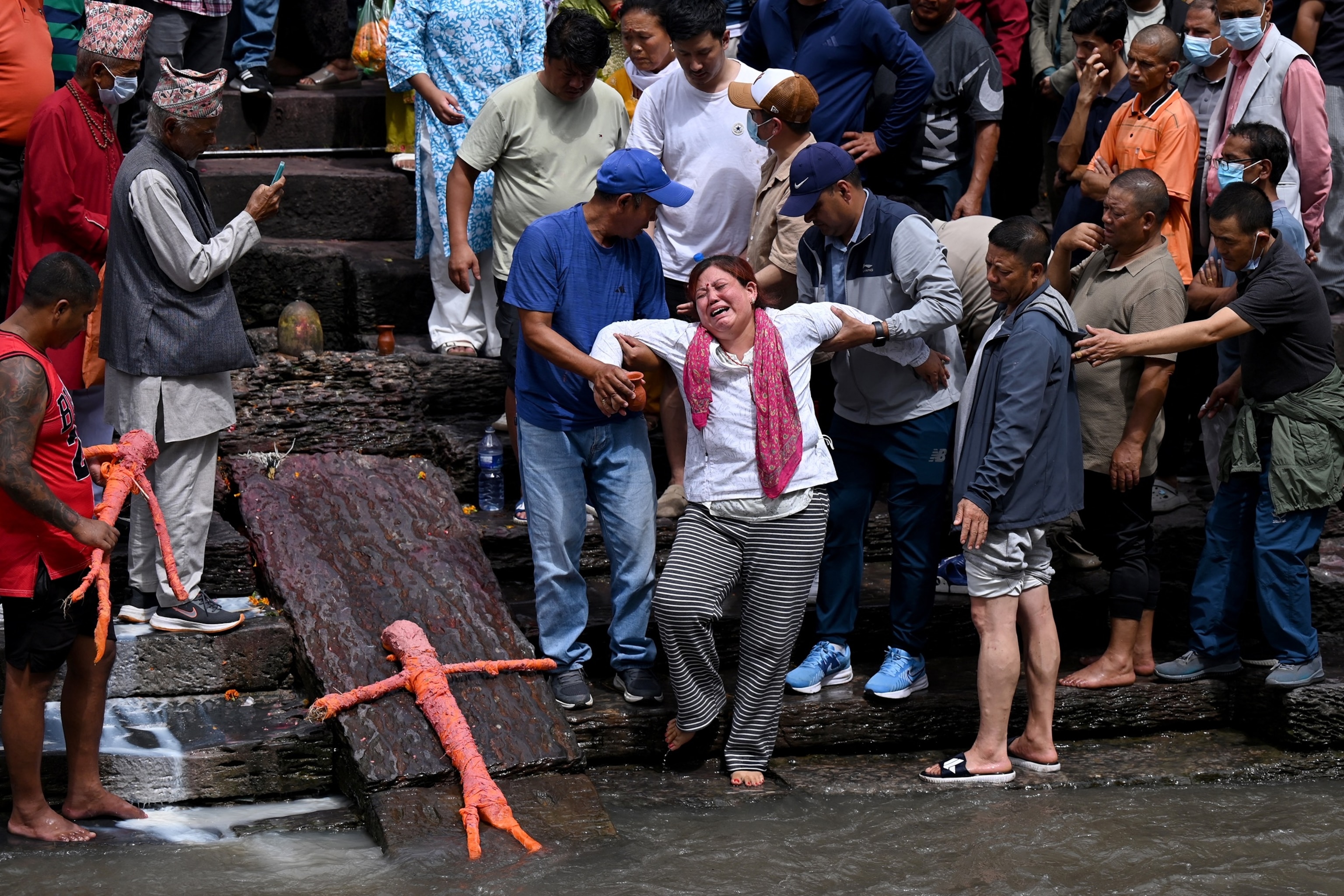 Relatives mourn during symbolic funerals held for flood victims still reported missing as they cremate Kush grass effigies in accordance with Nepali Hindu rites at Pashupatinath temple in Kathmandu on September 2, 2026.Prakash Mathema/AFP via Getty Images