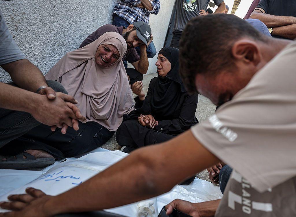 Image caption,Palestinians grieve over bodies of people killed in an Israeli attack targeting a beachfront cafe in Gaza City