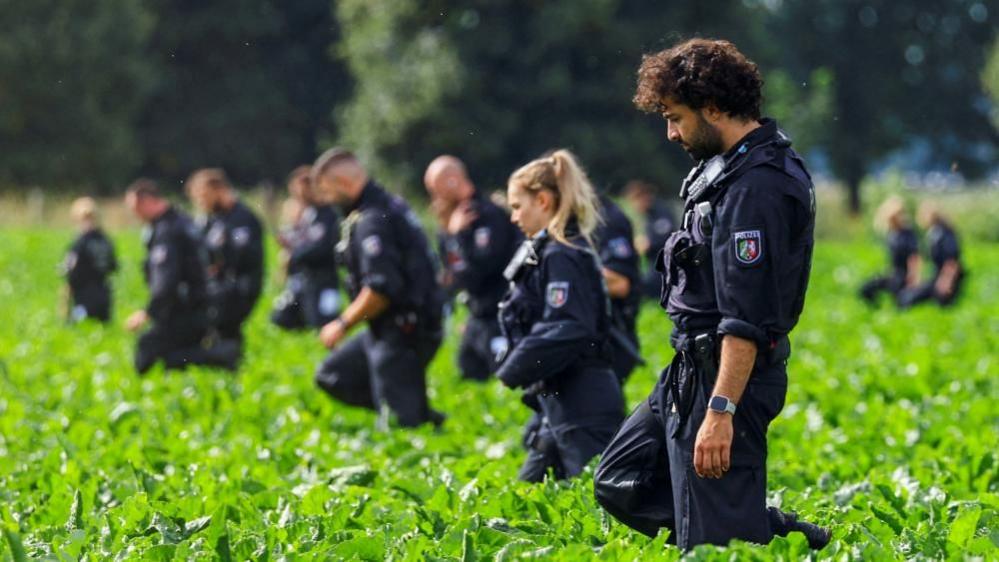 Image caption,Police search an area in Bergheim after an attack on a substation