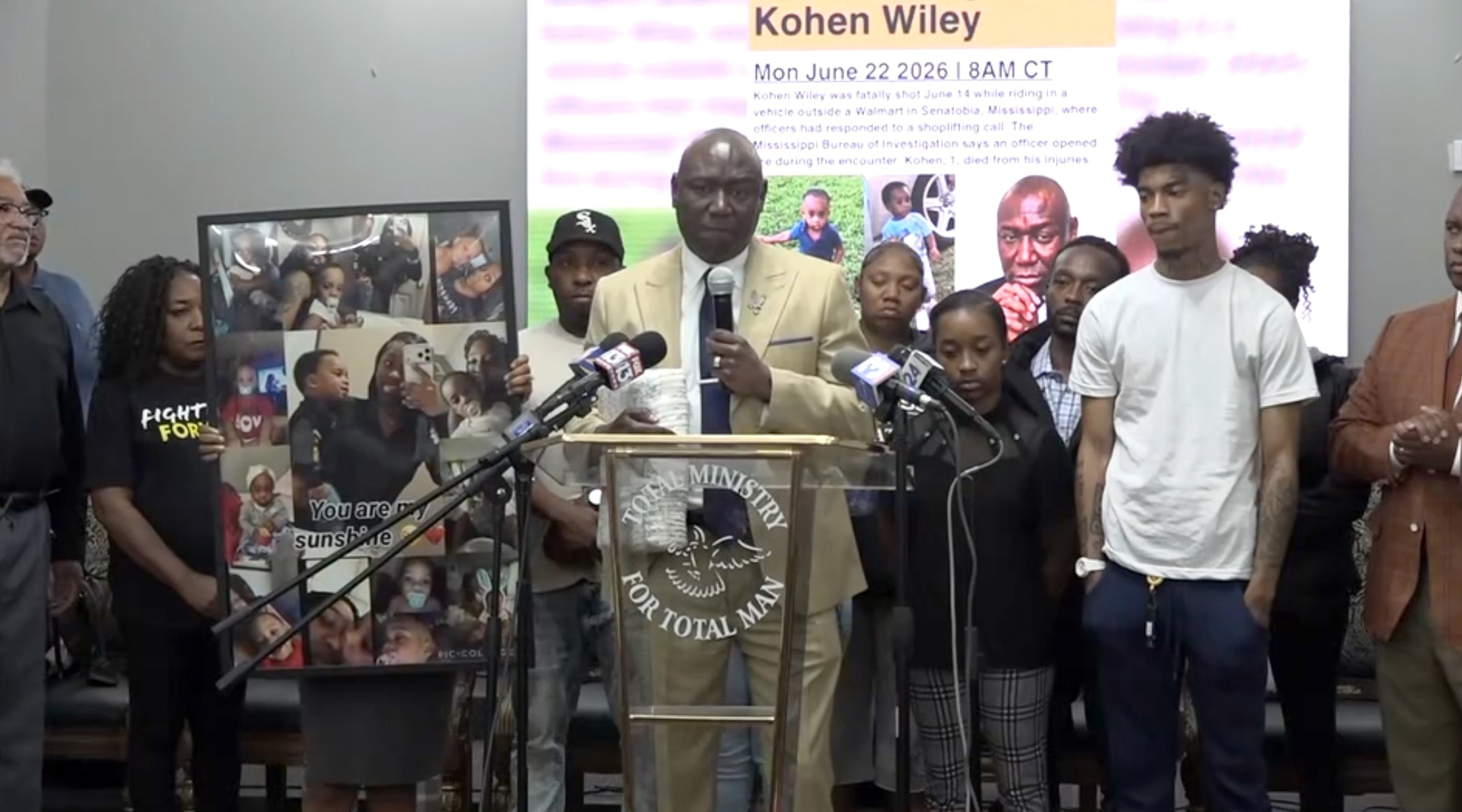 Attorney Ben Crump, at podium, is joined by members of Kohen Wiley's family during a press event in Senatobia, Mississippi, June 22, 2026.WATN