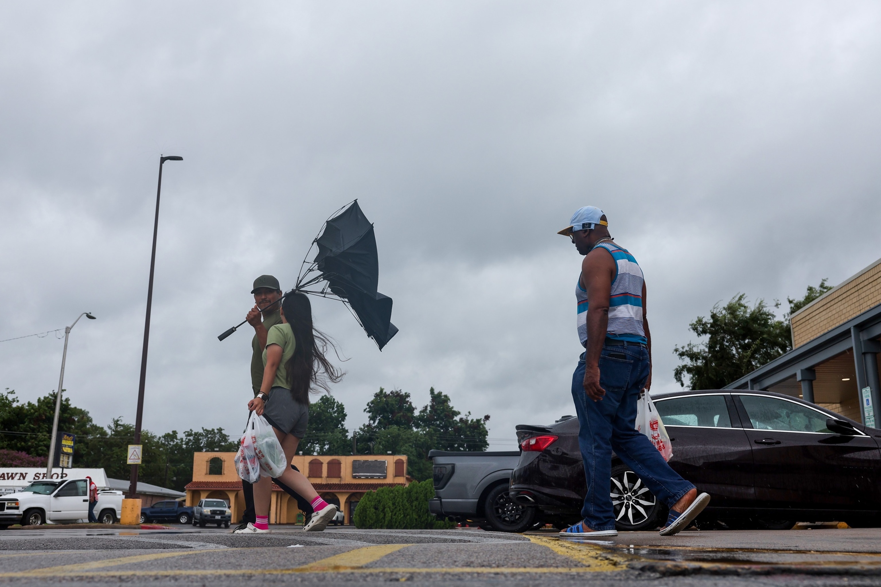 A man tries to hold onto an umbrella as he walks out of an H-E-B as Tropical Storm Edouard approaches, September 1, 2026, in Port Arthur, Texas.Antranik Tavitian/Getty Images
