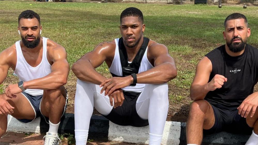 Image caption,The former heavyweight champion was a passenger in the crash, which killed his team members Latif Ayodele (left) and Sina Ghami (right)