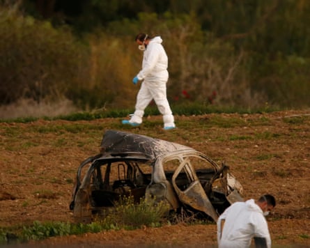 Forensic experts examine the field where a bomb blew up Daphne Caruana Galizia’s rental car.Photograph: Darrin Zammit Lupi/Reuters